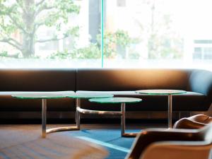 two tables in front of a couch with a window at WPÜ HOTEL Shinjuku in Tokyo +46 photos