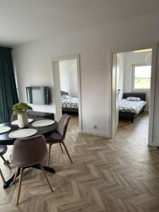 Cette chambre comprend une table, des chaises et deux miroirs. dans l'établissement ColourApartament, à Oława