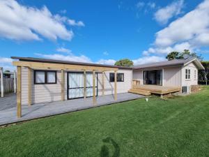 a modular home with a large yard at Lola's Beach Cottage in Hahei
