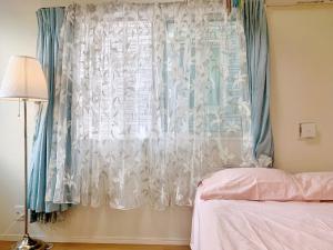 a bedroom with a window with a white curtain at JR t akadababa subway 5 mins walk! Newly building 新築! 高田馬場駅 徒歩圏内大人気! Shinjuku新宿圈!高速无限制Wi-FI BC in Tokyo +4 photos