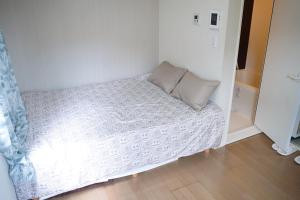 a small bed in a small room with a pillow at JR t akadababa subway 5 mins walk! Newly building 新築! 高田馬場駅 徒歩圏内大人気! Shinjuku新宿圈!高速无限制Wi-FI BC in Tokyo