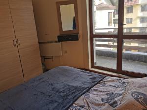 a bedroom with a bed and a window at ICEBERG Ski Apartment No19 in Pamporovo