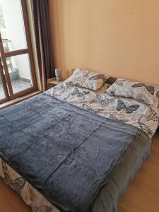 an unmade bed in a bedroom with a window at ICEBERG Ski Apartment No19 in Pamporovo