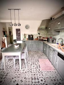 a kitchen with a table with chairs and a sink at Ô Nid Douillet in Ornans +8 photos