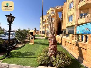 a lawn in front of a building with a street light at Reef House in Marsa Alam City