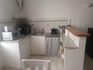 a kitchen with a microwave and a stove top oven at Grand Studio meublé chez COCO in Romans-sur-Isère
