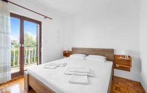 a bedroom with a white bed with a large window at Nice Apartment In Sibenik With Wifi in Šibenik +22 photos