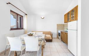 a kitchen and dining room with a table and white chairs at Awesome Apartment In Sibenik With Wifi in Šibenik
