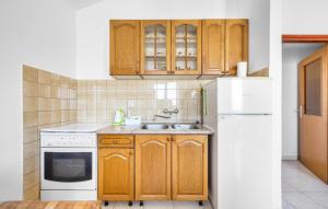 a kitchen with wooden cabinets and a white refrigerator at Awesome Apartment In Sibenik With Wifi in Šibenik +21 photos