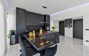 une cuisine avec des armoires noires, une table et des chaises dans l'établissement 3 Bedroom Gorgeous Home In Sorici, à Šorići