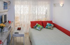 a living room with a couch with red pillows at Pet Friendly Apartment In Torremolinos in Torremolinos +15 photos