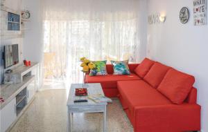 a red couch in a living room with a table at Pet Friendly Apartment In Torremolinos in Torremolinos