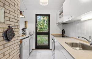 a kitchen with a sink and a brick wall at 2 Bedroom Lovely Home In Frederiksværk in Frederiksværk