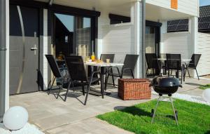 a patio with a table and chairs and a grill at 2 Bedroom Cozy Home In Sarbinowo in Sarbinowo