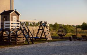 a playground with a slide and a swing at 2 Bedroom Cozy Home In Sarbinowo in Sarbinowo