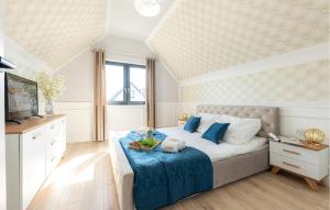 a bedroom with a large bed with a blue blanket at 2 Bedroom Cozy Home In Sarbinowo in Sarbinowo