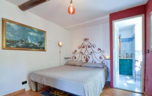 ピエーヴェ・リーグレにある1 Bedroom Nice Home In Pieve Ligureのベッドと壁に絵が飾られた寝室