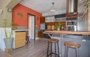 eine Küche mit orangefarbenen Wänden und Holzhockern in der Unterkunft 3 Bedroom Stunning Home In Arles in Arles