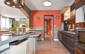 eine große Küche mit orangefarbenen Wänden und Holzböden in der Unterkunft 3 Bedroom Stunning Home In Arles in Arles