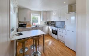 a kitchen with white cabinets and a white refrigerator at 3 Bedroom Nice Home In Lyngdal in Lyngdal
