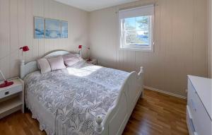 a bedroom with a white bed and a window at 3 Bedroom Nice Home In Lyngdal in Lyngdal