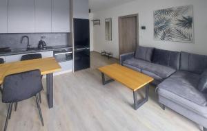 Una cocina y una sala de estar con un sofá y una mesa. en 1 Bedroom Nice Apartment In Sianozety, en Sianożęty