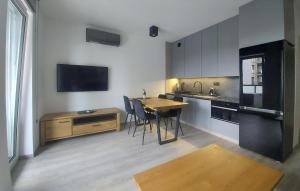 cocina con mesa y sillas y TV en 1 Bedroom Nice Apartment In Sianozety, en Sianożęty