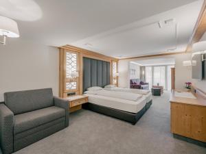 sypialnia z łóżkiem, kanapą i krzesłem w obiekcie Gourmet & Wine Hotel Austria - 4 Sterne superior w mieście Obergurgl
