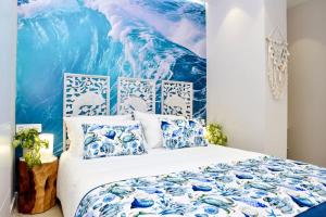 a bedroom with a bed with blue and white pillows at La Sirena Playa B in Puerto de la Cruz