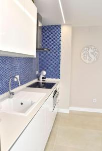 a white kitchen with a sink and a shower at La Sirena Playa B in Puerto de la Cruz
