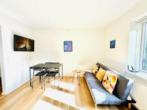 una sala de estar con un sofá y una mesa en aday - Charming and Bright Studio Apartment, en Aalborg
