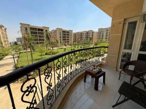 einen Balkon mit Blick auf einen Park und Gebäude in der Unterkunft Charming Apartment 2 Bedroom In El Rehab in Burg el-Ḥudûd