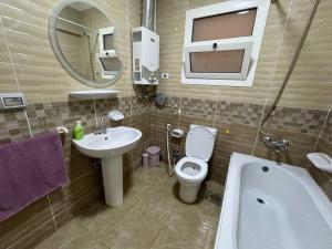 ein Badezimmer mit Toilette, Waschbecken und Badewanne in der Unterkunft Charming Apartment 2 Bedroom In El Rehab in Burg el-Ḥudûd + 34 Fotos