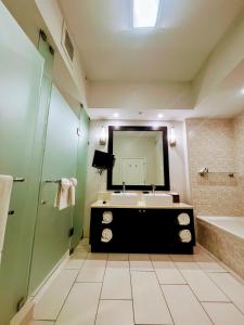 Un baño con lavabo, bañera y espejo. en Doral Pool 1107 by Wave Properties, en Miami