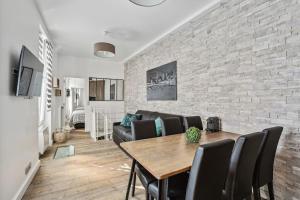 a living room with a table and a brick wall at 03 Tour Eiffel Appartement pour 7 personnes in Paris