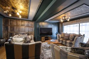 a living room with couches and a flat screen tv at Luxury 2 Bed Manor House Hot Tub Cinema Room SkyTV in Saffron Walden