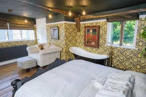 a bedroom with a bed and a chair at Luxury 2 Bed Manor House Hot Tub Cinema Room SkyTV in Saffron Walden