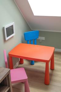 a brightly colored table and chair in a room at Küstenblick in Carolinensiel +3 photos