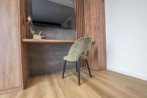 a green chair in a room with a mirror at Küstenblick in Carolinensiel
