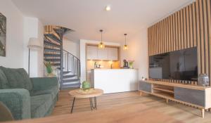 a living room with a green couch and a kitchen at Küstenblick in Carolinensiel