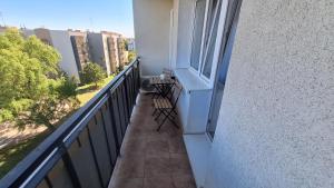 Un balcón con un banco y una ventana. en Magmares Apartment, en Bydgoszcz