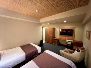 a hotel room with two beds and a television at Kadoya Hotel in Tokyo