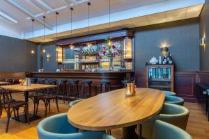 a restaurant with wooden tables and chairs and a bar at Landgoed de Horst in Driebergen