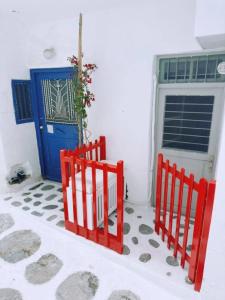 two red fences in front of a blue door at Bougainvillea Friends & Family Studio - Old Town in Mýkonos City