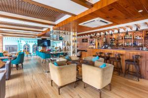 a restaurant with tables and chairs and a bar at Dream International Hotel in Rummindei