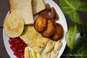 a plate of breakfast food with toast potatoes and bread at Nana Jungle Resort Near Chitwan National Park in Bharatpur