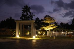 un monument illuminé dans un parc la nuit dans l'établissement Leela's 7th Heaven Resort & Spa, à Turcunapulli