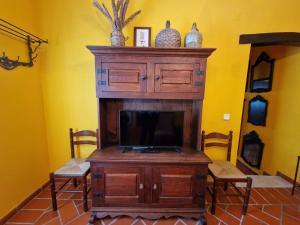 a tv sitting on top of a wooden entertainment center at Casa do Avô Lopes in Tomar