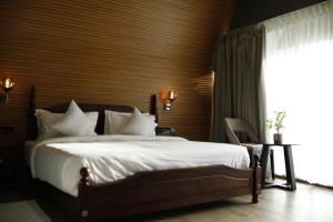 une chambre avec un lit avec des draps blancs et une fenêtre dans l'établissement Leela's 7th Heaven Resort & Spa, à Turcunapulli