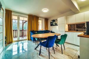 kuchnia i jadalnia ze stołem i krzesłami w obiekcie Luksusowy Apartament Ametyst z Prywatną Sauną w Świeradowie Zdroju